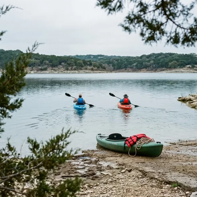 Two kayakers paddling away from a boat ramp, kayaking near Georgetown on a calm Texas lake