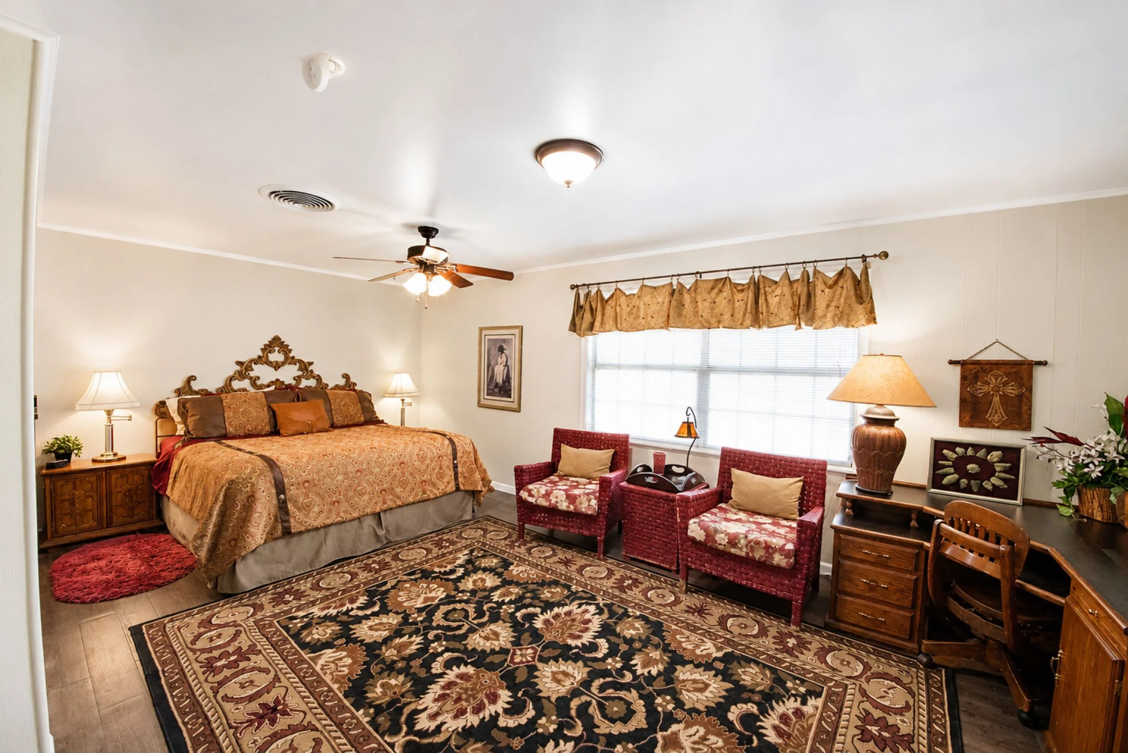 Master bedroom with ornate headboard and damask bedding at Georgetown vacation rental farm with river view