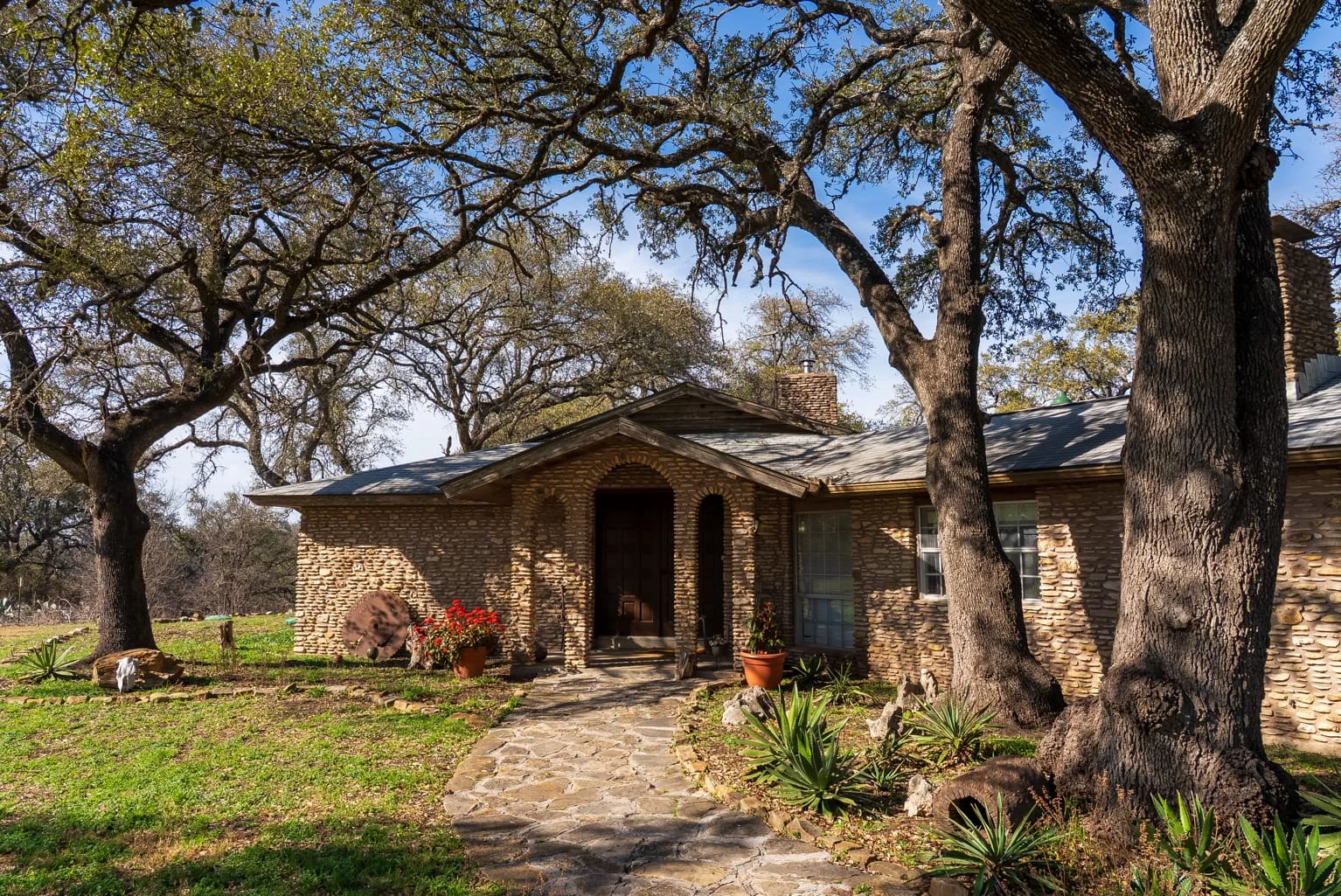 Dog friendly cabin Georgetown TX stone cottage exterior with oak trees at Scurlock Farms