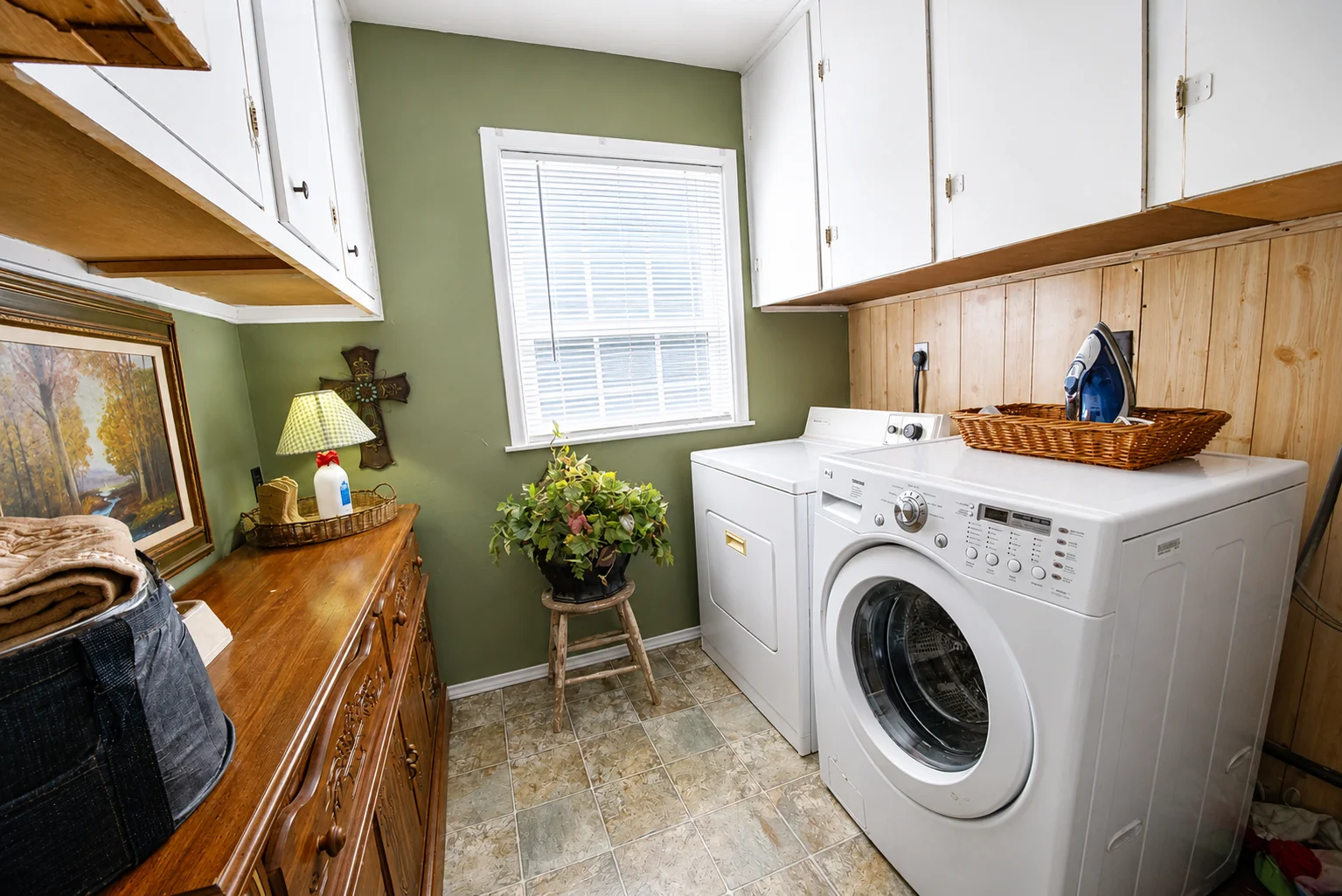 Modern farmhouse laundry room with sage green walls and white washer dryer at Scurlock Farms