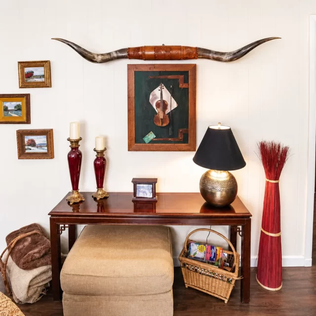 Elegant Georgetown TX living room with rustic Western console table, brass candlesticks, and longhorn wall art