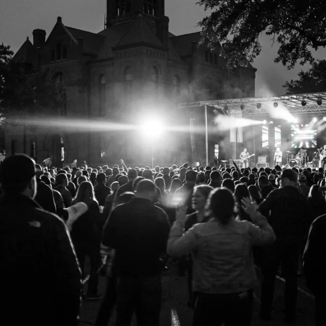 Crowd silhouettes at an evening concert on a courthouse square, a fun thing to do in Georgetown, TX